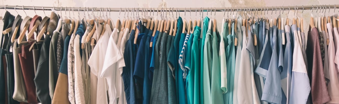 A row of colourful vintage clothes on hangers