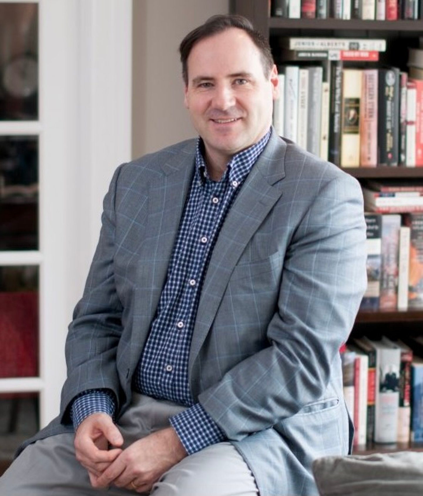 a man standing in front of a book shelf