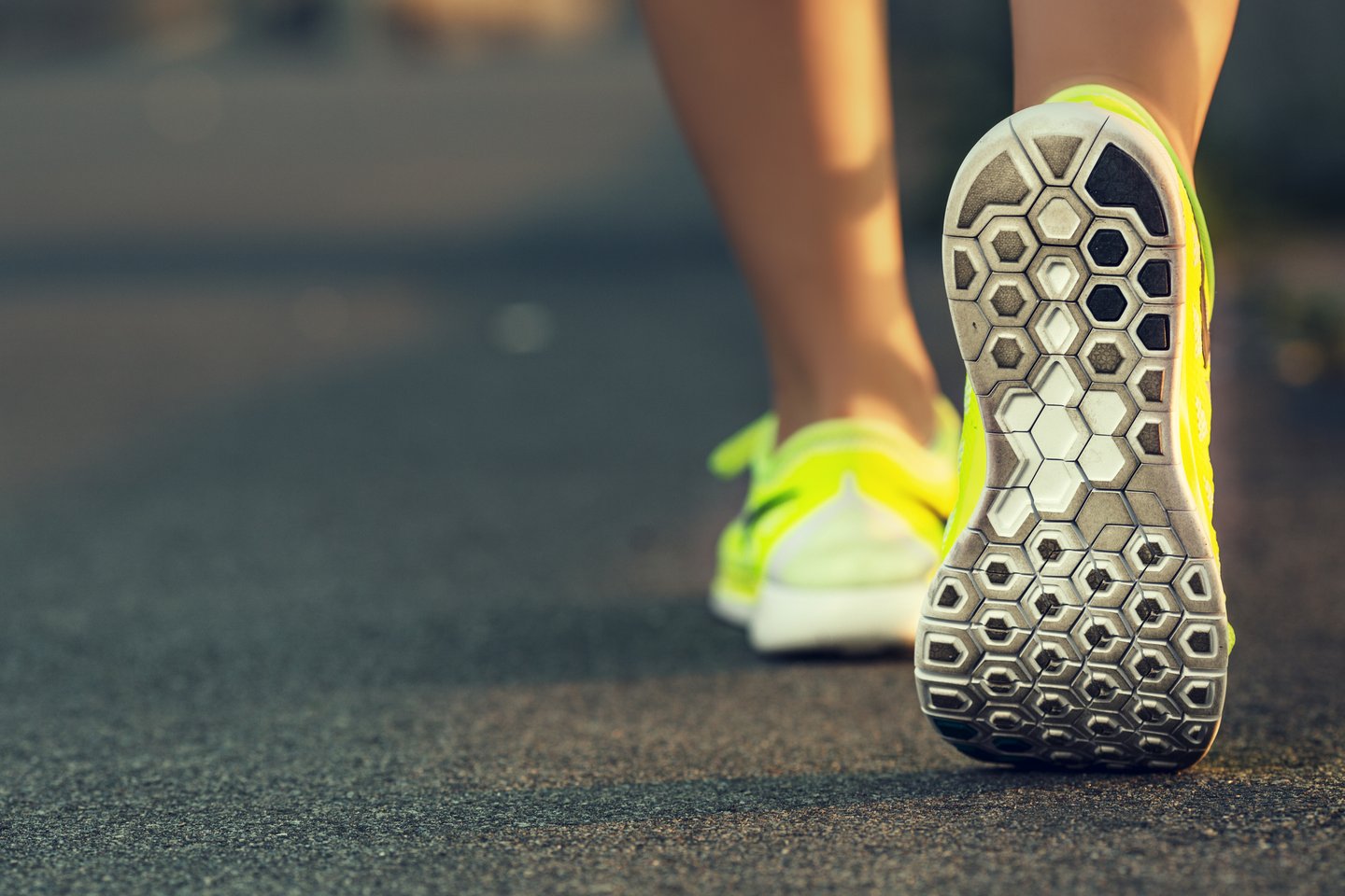 Close-up of a woman walking away in tennis shoes