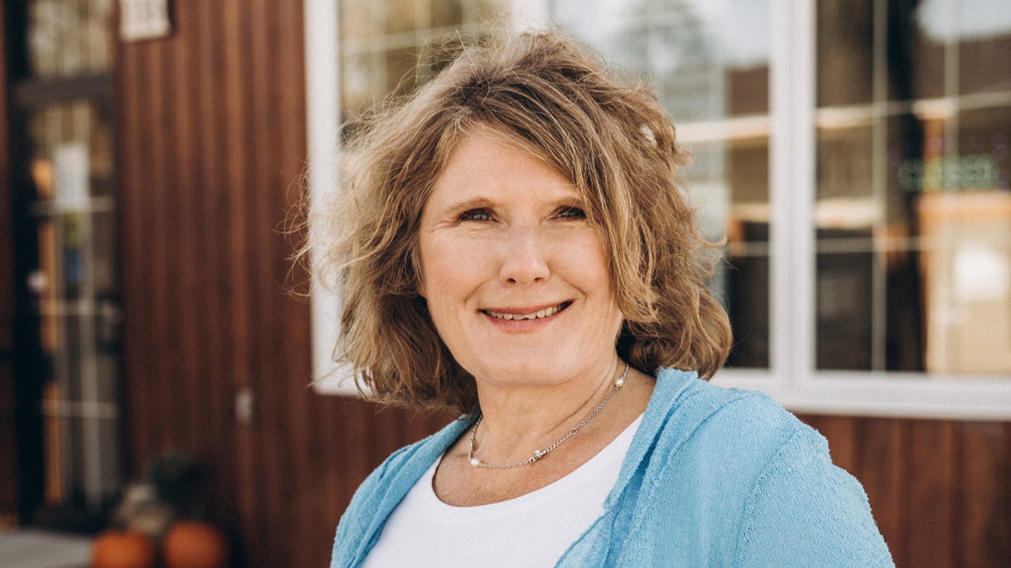 A smiling woman in a blue cardigan