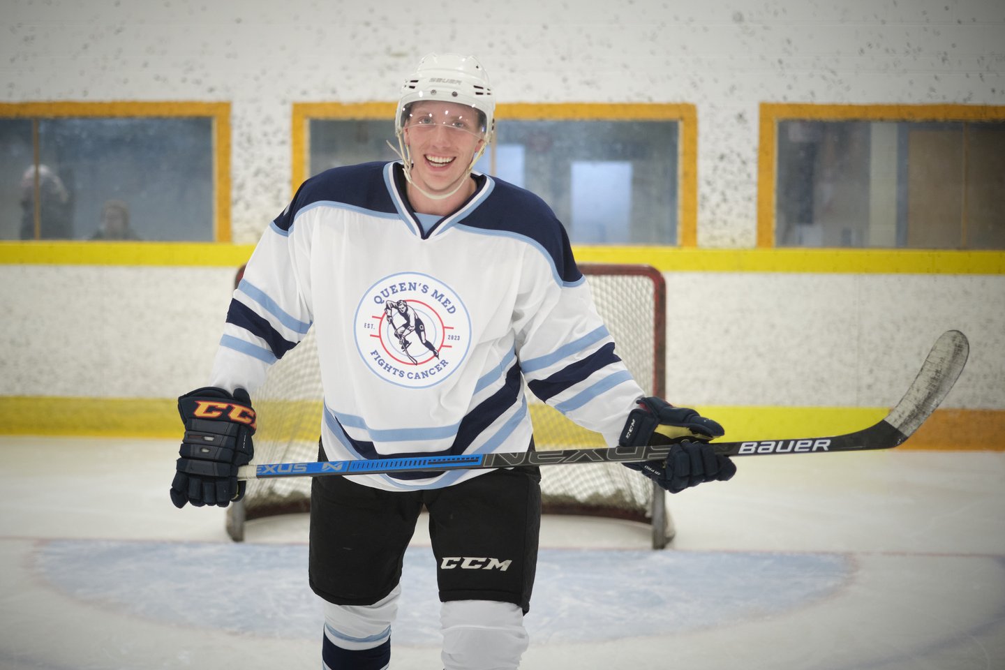 Man in hockey gear on the ice holding a hockey stick