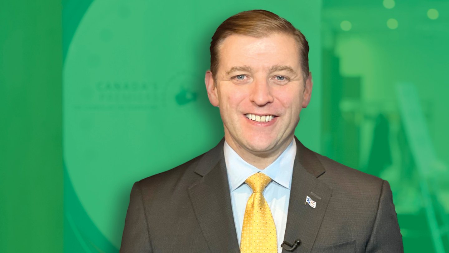 A man in a suit in front of a green background