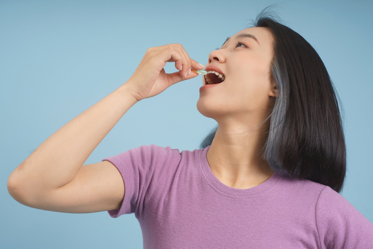 Asian female taking a pill
