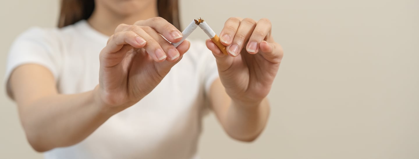 Girl breaking cigarette in half