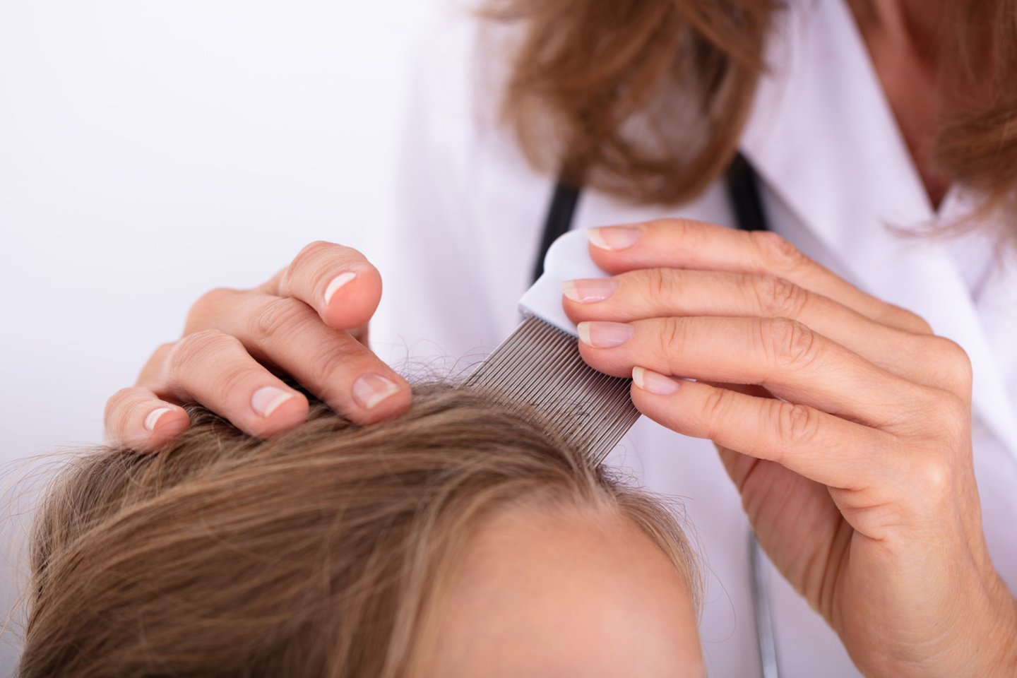 Female healthcare professional evaluating a woman's scalp