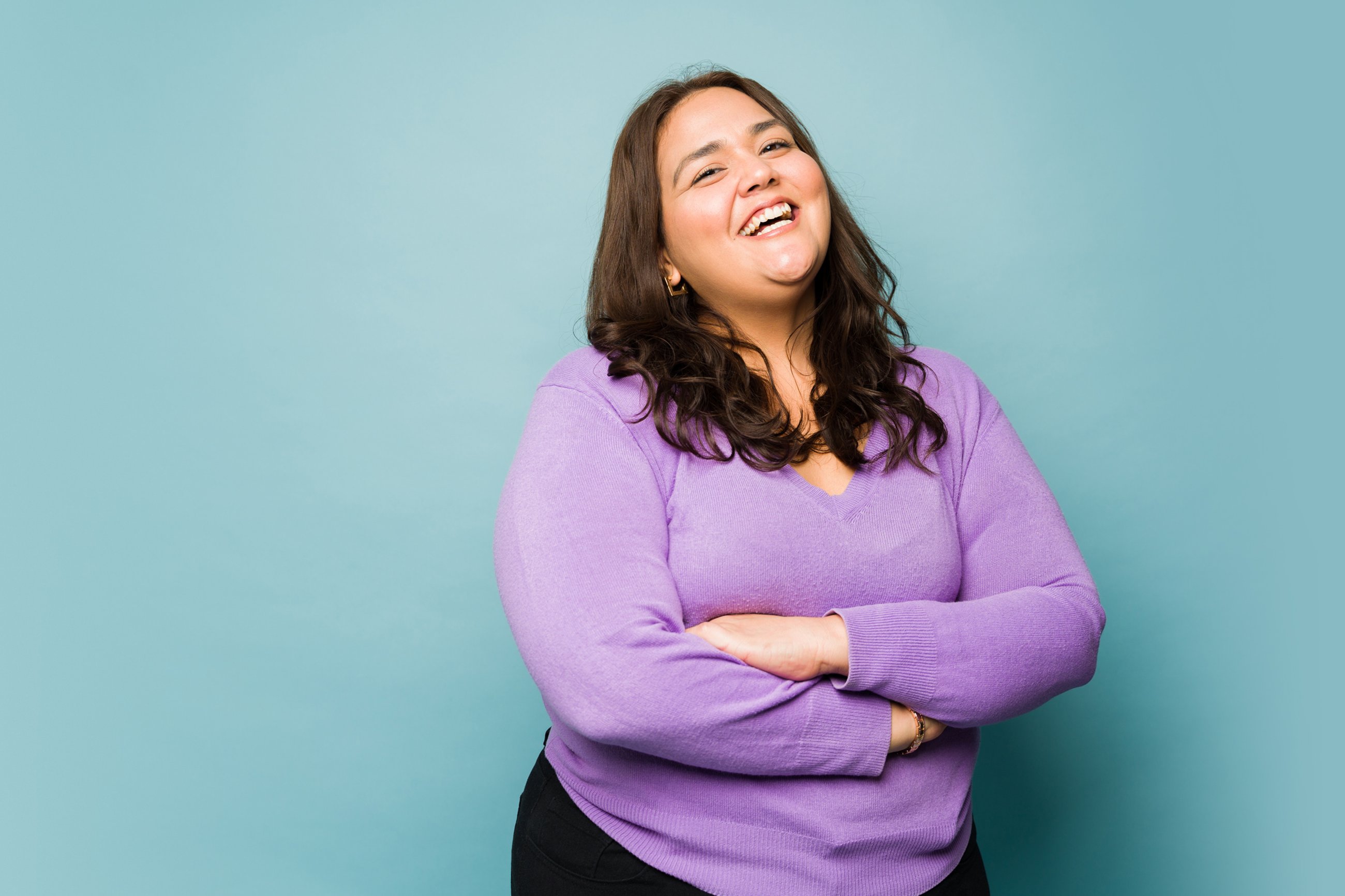 Smiling woman standing against a blue backdrop