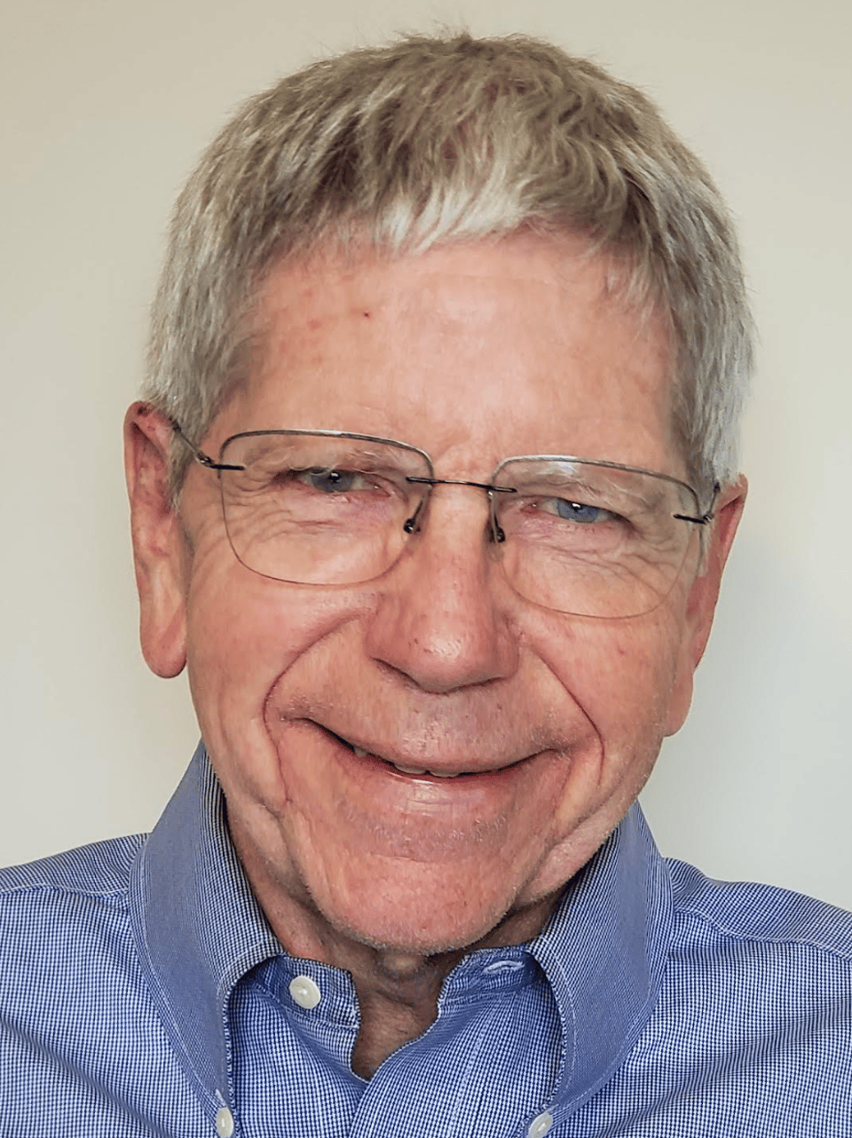 Older man in blue shirt smiling for a photo