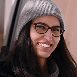 a woman wearing glasses and smiling at the camera