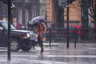 a person walking down a street holding an umbrella in the rain