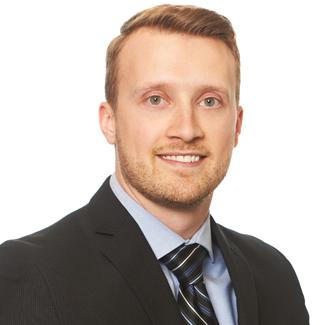 a man wearing a suit and tie smiling at the camera