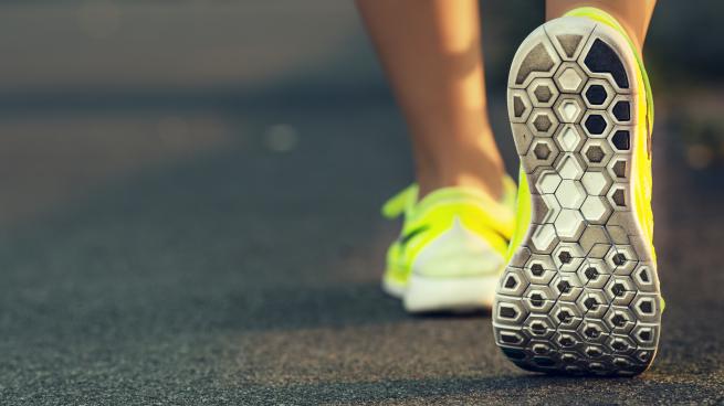 Close-up of a woman walking away in tennis shoes